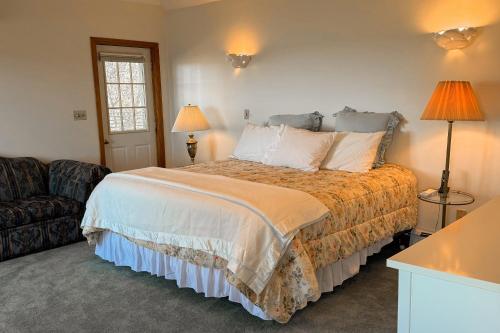 een slaapkamer met een groot bed en een bank bij La Casa De La Playa in Lanesville