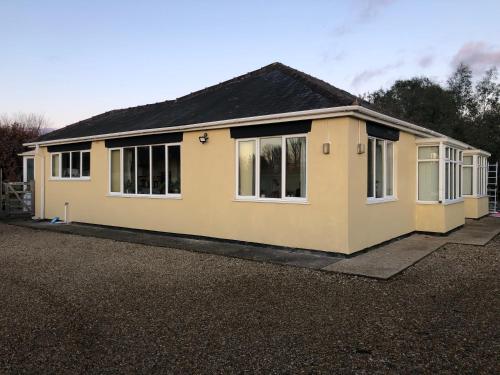 ein gelbes Haus mit Fenstern auf einem Grundstück in der Unterkunft Home Thyme Holding in Upwell