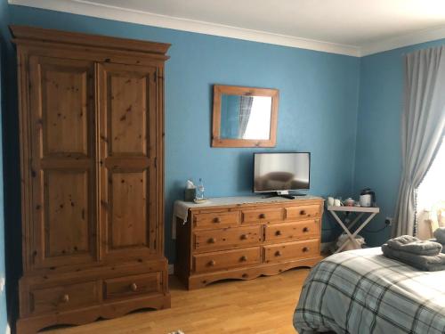 ein Schlafzimmer mit einem Bett und einem Fernseher auf einer Kommode in der Unterkunft Home Thyme Holding in Upwell