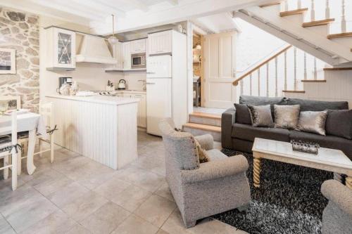 un soggiorno con un divano, un tavolo e una cucina di Casa de Carmen Bañera, chimeneas de leña y terraza a Corcubión