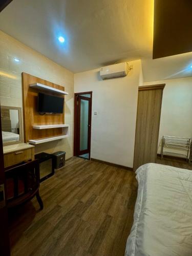 a hotel room with a bed and a tv and a bedroom at Kubu alit guest house Seminyak in Seminyak