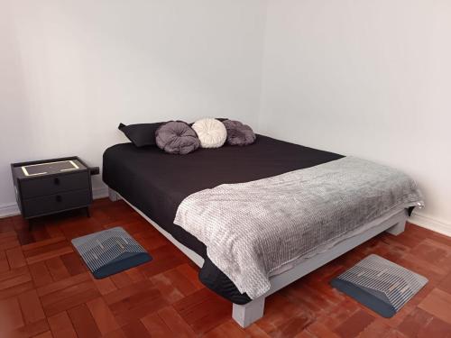 a bedroom with a black bed with two pillows at GuestHouse Habitaciones SANTIAGO CENTRO in Santiago