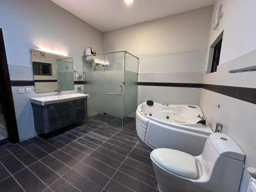 Un baño con bañera, inodoro y lavabo. en Hyatt Residency, en Islamabad
