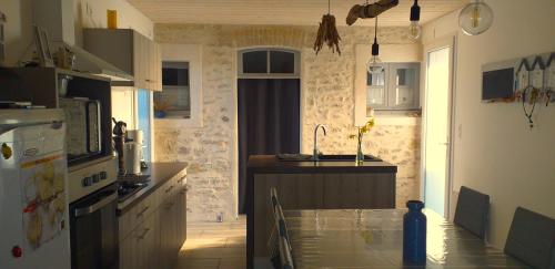 a kitchen with a table and a sink in it at Maison 6 personnes in Barbâtre