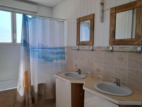 un bagno con due lavandini e una doccia di Chez Monique 