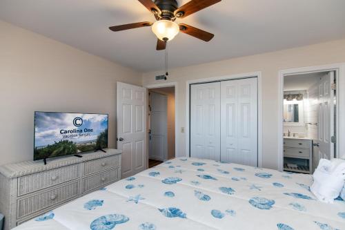 een slaapkamer met een bed en een flatscreen-tv bij 214 Bay Creek Villa in Edisto Beach