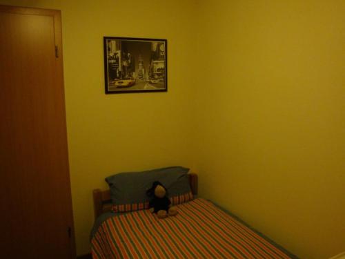 un orsacchiotto seduto su un letto in una camera da letto di Hausboot Levitate im Hafen von Barßel a Barßel