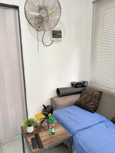 a room with a couch and a fan and a table at Hlones place in Rustenburg