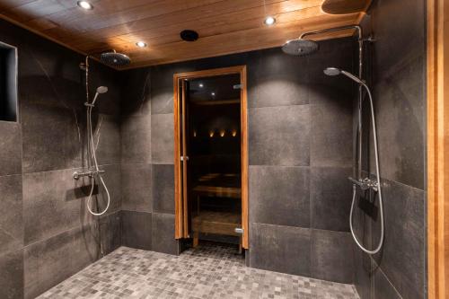 a bathroom with a walk in shower and a mirror at Villa Levilla, luxury in Levi in Levi