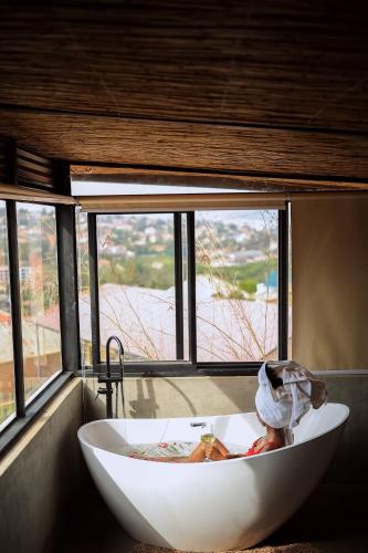 a white bath tub in a room with a window at Ndare Eco Ville in Kigali