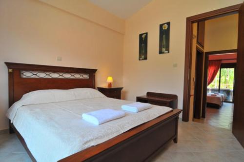 クリッシ・アモウディアにあるMeltemi Villaのベッドルーム1室(大型ベッド1台、白いタオル2枚付)