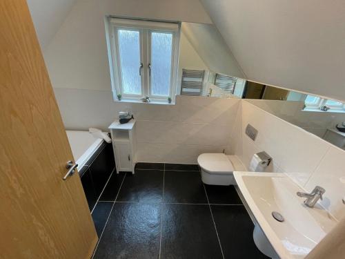 a bathroom with a toilet and a sink at Trewhiddle Retreat V12 by Together Travel - Luxury 4-Bedroom Villa in St Austell