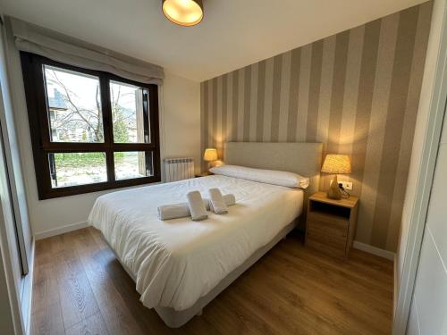 a bedroom with a bed with two towels on it at Villmor - B11 - Pichirillo in Benasque