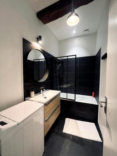 a bathroom with a sink and a tub and a mirror at La vue sacrée in Laon
