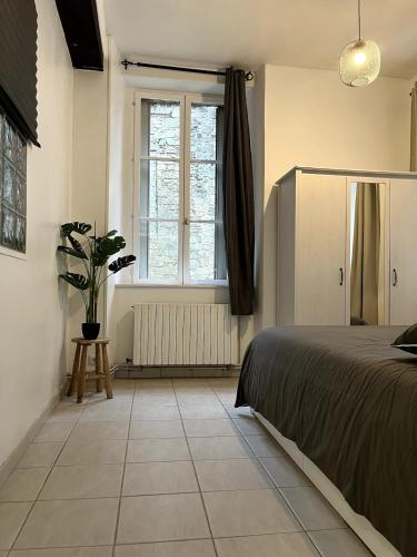 Un dormitorio con una cama y una ventana en La vue sacrée, en Laon