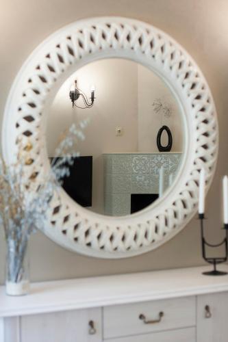 a mirror on top of a dresser in a bathroom at Apartments Satva in Vilnius