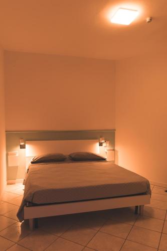 ein Schlafzimmer mit einem Bett mit Lampen in der Unterkunft WowMilano Escape in Melegnanello