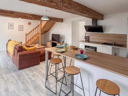 a kitchen and living room with a table and stools at Entre Bressuire & Thouars- By R&G in Coulonges-Thouarsais