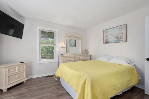 ein weißes Schlafzimmer mit einem gelben Bett und einem Fenster in der Unterkunft DK207 The Big Sea in North Point