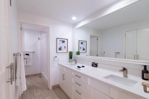 un bagno bianco con un grande specchio e un lavandino di Sonoran Spa E301 a Campo del Medio