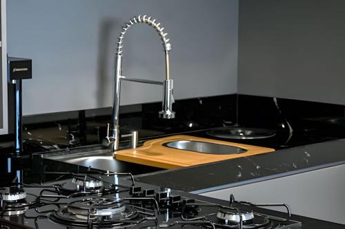 eine Küchentheke mit einem Waschbecken und einem Waschbecken in der Unterkunft Cobertura duplex de frente pro mar in Natal