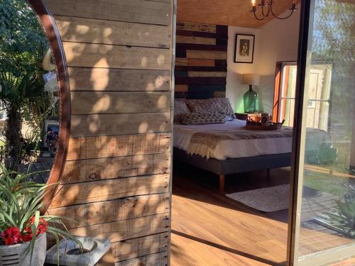 a bedroom with a bed and a mirror in a room at Cabina & Tinaja con vista al Rio Maipo in Pirque