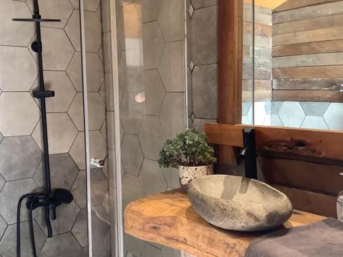 a bathroom with a stone sink on a wooden counter at Cabina & Tinaja con vista al Rio Maipo in Pirque