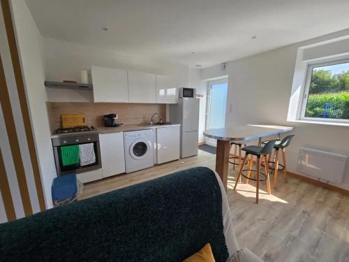 een kamer met een keuken en een tafel met stoelen bij A la folie in Folligny