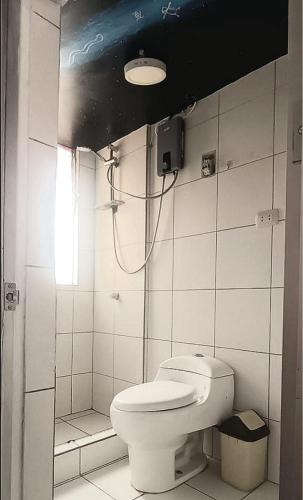 a bathroom with a white toilet and a shower at Aguaymanto pisac hostel in Pisac