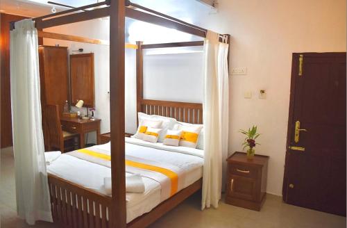 Schlafzimmer mit Himmelbett in der Unterkunft The Boho Stays Kochi in Kochi