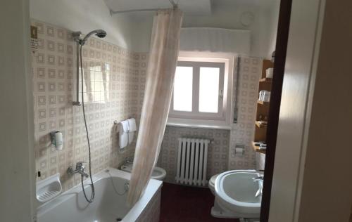 La salle de bains est pourvue d'une baignoire, de toilettes et d'un lavabo. dans l'établissement Meuble Villa Neve, à Cortina dʼAmpezzo