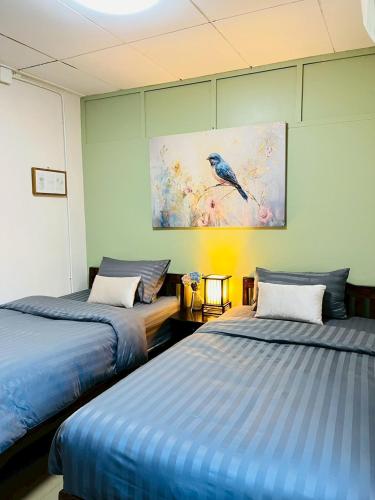 a room with two beds and a painting on the wall at Boutique Hotel & Restaurant, Jaidee Bamboo Huts in Chiang Mai