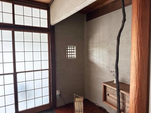 una stanza con grandi finestre e una parete con un camino di sikari Vacation STAY 95401v a Takashima