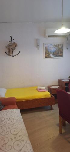 Cette chambre comprend un lit jaune. dans l'établissement Apartman Villy 2, à Jadranovo