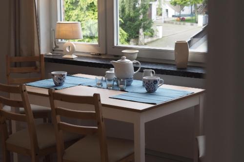 un tavolo e delle sedie con un tavolo e una finestra di Appartment Buntspecht - Gemütliche Ferienwohnung, Direkt am Wald, Nähe zur Altstadt a Mölln