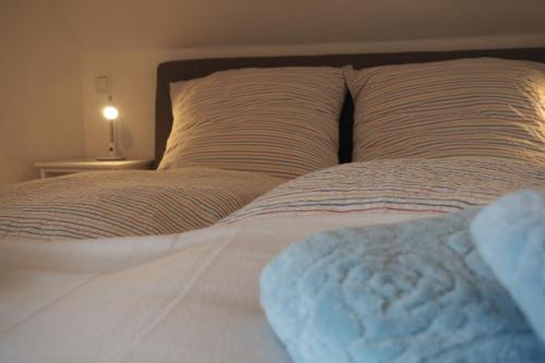 un letto con due cuscini sopra di Appartment Buntspecht - Gemütliche Ferienwohnung, Direkt am Wald, Nähe zur Altstadt a Mölln