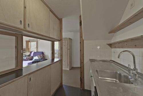 een keuken met een spoelbak en een aanrechtblad bij Chesa Prasura - Celerina in Celerina