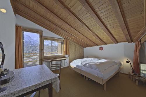 een slaapkamer met een bed en een groot raam bij Chesa Prasura - Celerina in Celerina