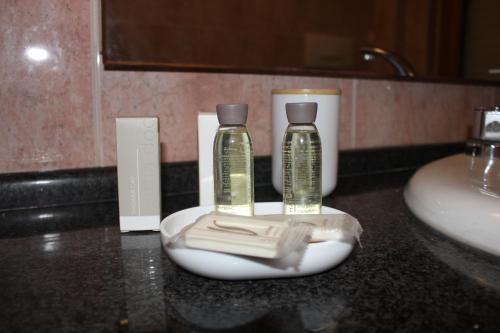 The Mazzitellis Home في نيتّونو: منضدة الحمام بها زجاجتان من الصابون ومغسلة