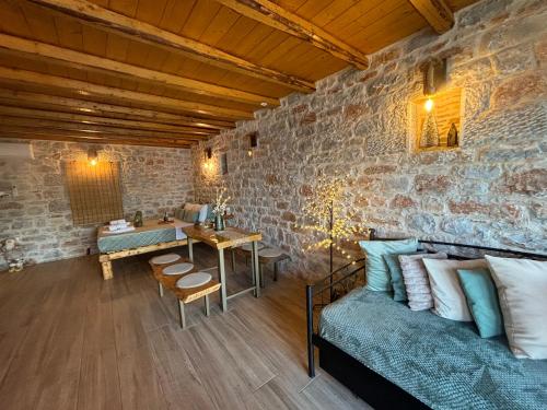 ein Wohnzimmer mit Sofa und Tisch in der Unterkunft Suite of Villa Lagkadaki in Agriliá