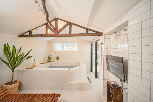 a bathroom with a tub and a tv in a room at 신흥부부공간a동 in Hamdŏng-ni