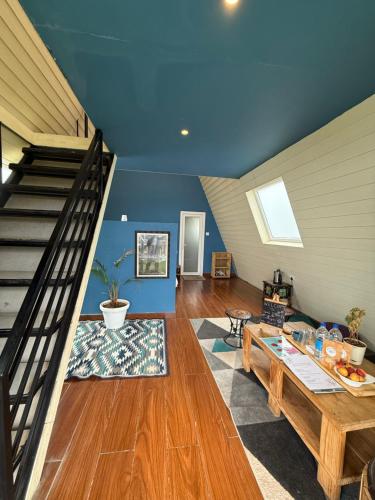 The Soul Stroll Cottages Retreat في مكتزور: غرفة معيشة بها درج وطاولة