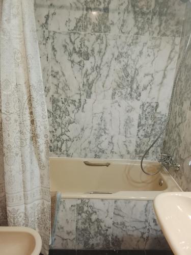 a bathroom with a marble shower curtain and a sink at La terraza del pilar in Zaragoza
