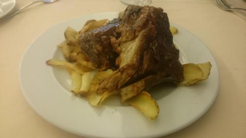 a plate of food with french fries on a table at Hotel Bristol in Lignano Sabbiadoro