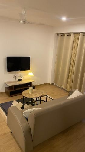 a living room with a couch and a tv at Flat in Viman Nagar in Pune