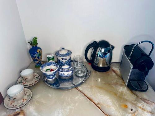 a counter top with cups and plates and a laptop at Evermoore Homestead in Gleniffer