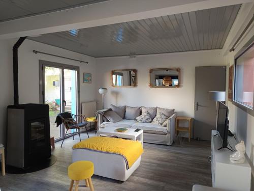 a living room with a couch and a tv at Les Bains in La Guérinière