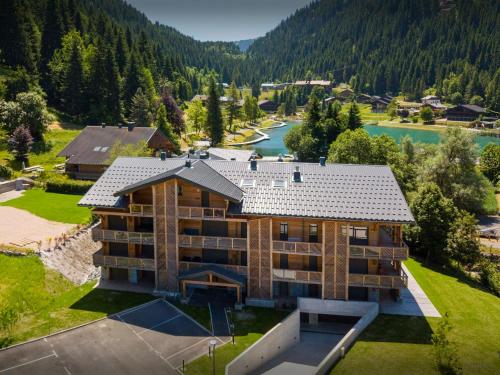 an aerial view of a large house with a river at Lodge Cresson - OVO Network in Châtel