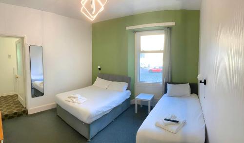 a small room with two beds and a window at Savoy Hotel in Weston-super-Mare