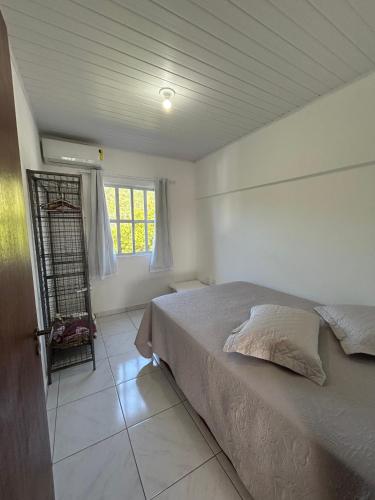 Un dormitorio con una cama y una ventana en Apartamento Orquídea, en Porto Belo